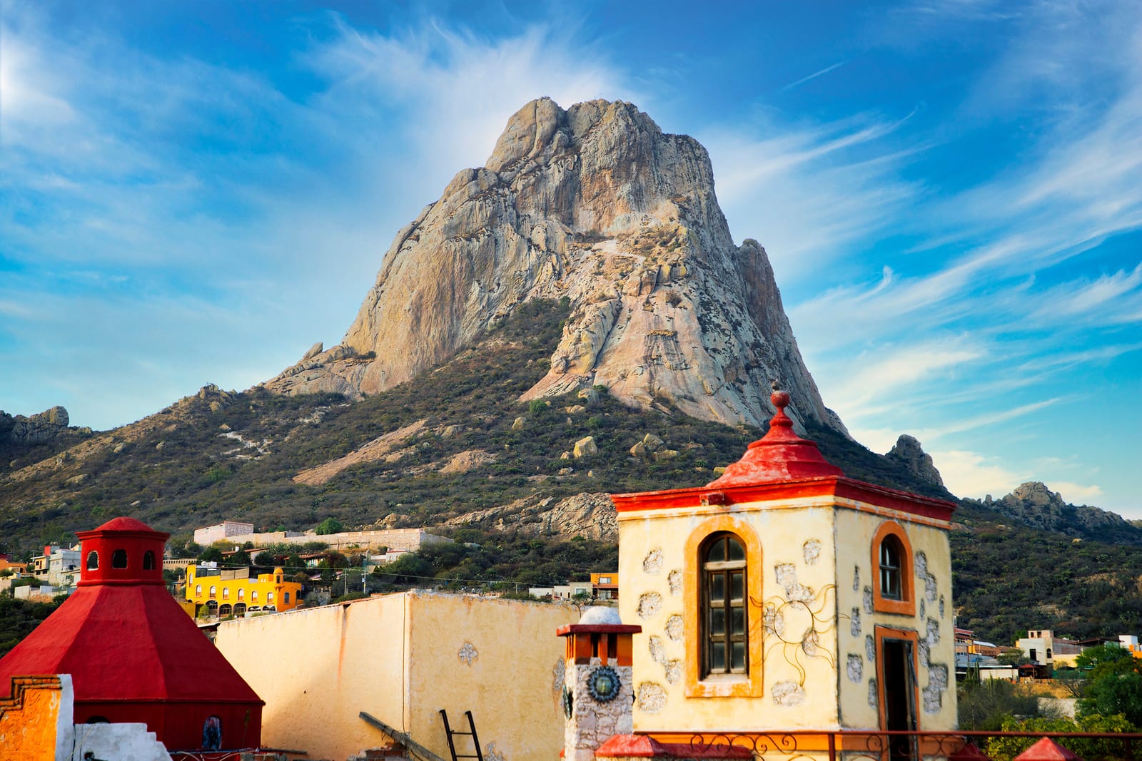 The Peña de Bernal monolith above Bernal's colorful rooftops