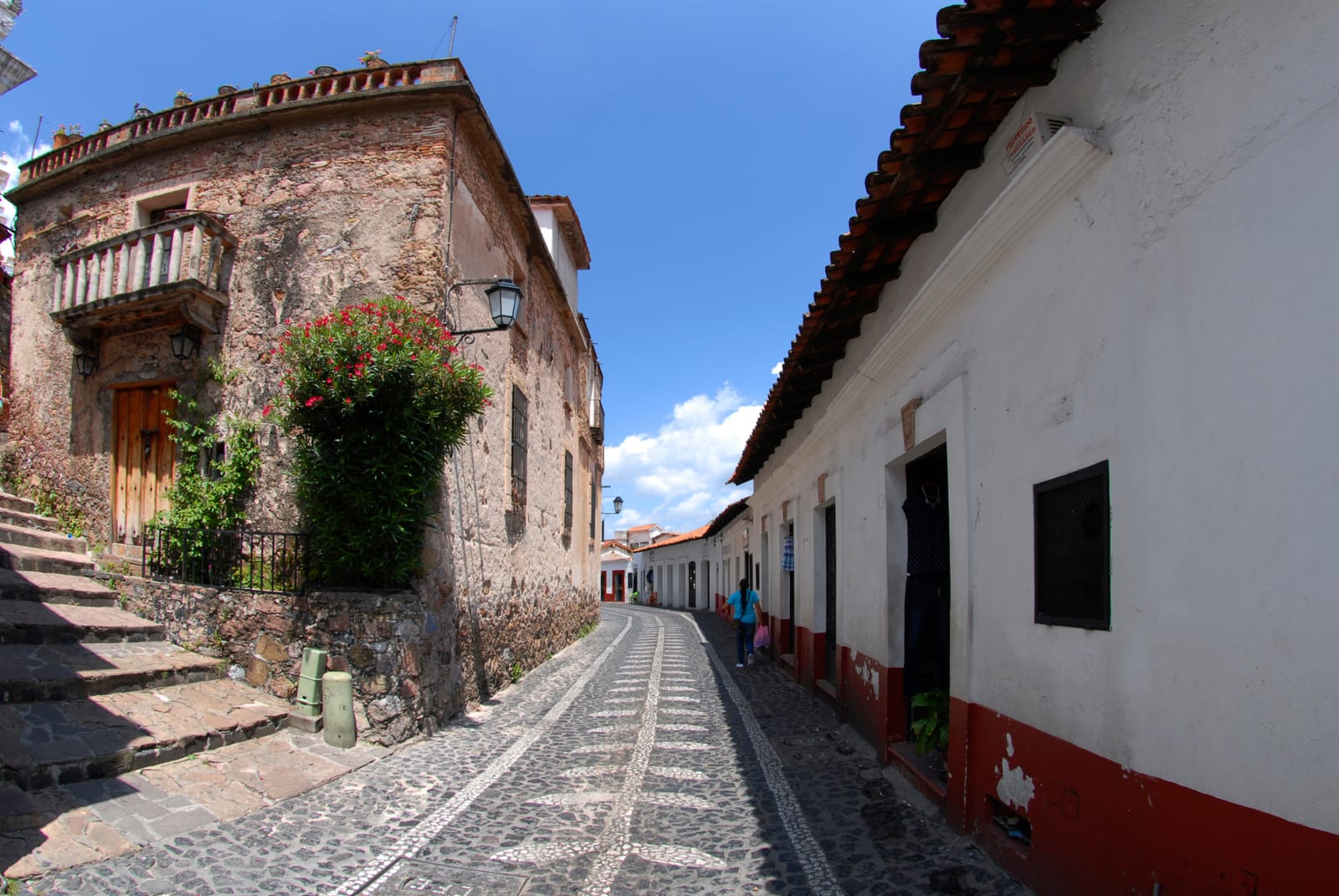Cobblestone lane between whitewashed walls in Taxco